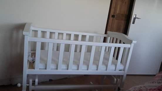 Rocking/ unrocking white crib great condition .. suitable from birth to six months