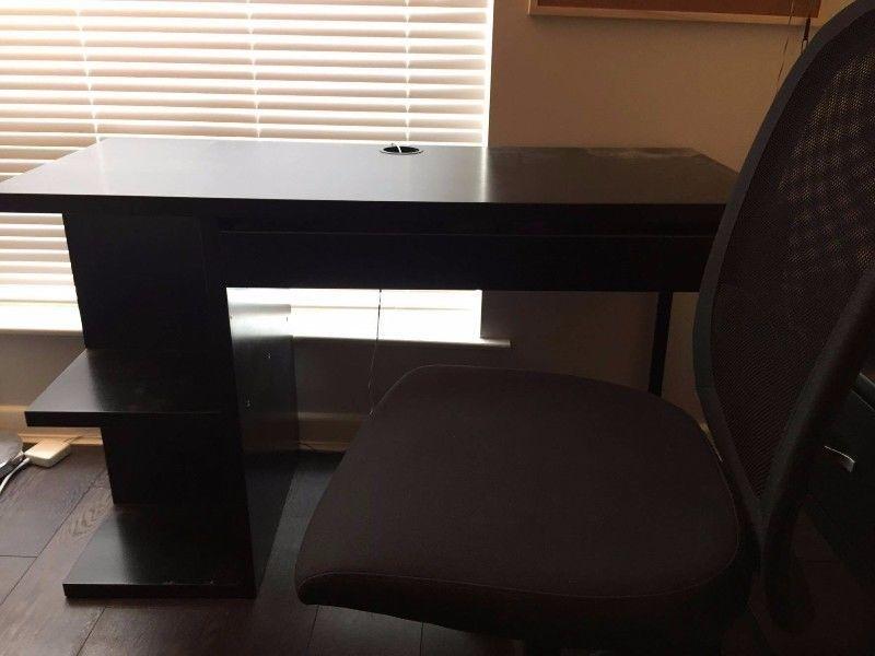 Black office desk and ergonomic chair