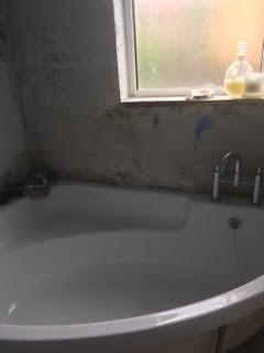 white corner bath and surround panel & mixer taps
