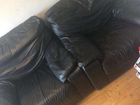 Two black leather arm chairs